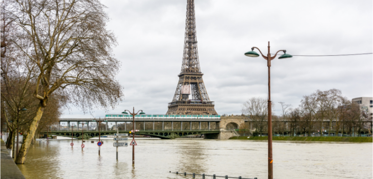 Image features Flooded Paris in 2018, with a overflowing Seine river and the Eiffel tour at the back
